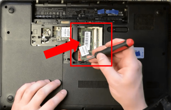 Removing the RAM compartment from the back of an Acer laptop.