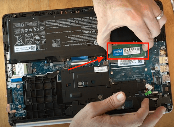 Inserting RAM stick into HP laptop.